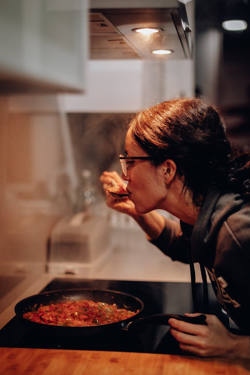woman eating on cooking pan